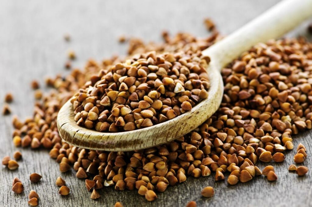 dried buckwheat grains on a wooden spoon